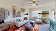 This single-story residence offers three bedrooms, one bathroom, and a thoughtfully arranged layout that maximizes functionality throughout. The combined kitchen and living area serves as the heart of the home, where a well-equipped kitchen features rich dark wood cabinetry, granite-style countertops, black appliances including a refrigerator, range, microwave, and dishwasher, and a breakfast bar with seating for two. Tile flooring and a ceiling fan complete the space. Adjacent to the kitchen, the living room offers carpeted floors, a ceiling fan, large windows that invite natural light, and wall space well-suited for artwork. The primary bedroom is a generously sized retreat with carpeted floors, a ceiling fan, and a window overlooking greenery. The two additional bedrooms are comfortably proportioned, each featuring carpet, ceiling fans, and windows that bring in natural light. The full bathroom includes a shower-tub combination with sliding glass doors, tile flooring, a vanity with dark wood cabinetry, and overhead storage. A hallway connects the rooms, contributing to a cohesive and practical floor plan. Throughout the residence, neutral wall tones and consistent finishes create a warm, unified ambiance.
