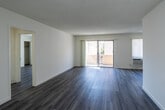 Located at 1025 S Holt Ave in the heart of Los Angeles, CA, this thoughtfully renovated single-floor residence combines contemporary finishes with a clean, functional layout. The galley-style kitchen is a standout feature, showcasing white shaker cabinetry, quartz countertops with elegant veining, a classic subway tile backsplash, stainless steel appliances including a refrigerator, range, microwave, and dishwasher, and a deep double-basin sink with a modern pull-down faucet. Light wood-style flooring flows seamlessly throughout the unit, lending warmth and cohesion to every room. The spacious living area is bright and airy, filled with natural light from large windows fitted with vertical blinds and a sliding glass door that opens to a private balcony. A ceiling fan adds comfort to the living space, which also features a wall-mounted AC unit. The bathrooms have been updated with marble-look quartz countertops, vessel or undermount sinks, brushed nickel and matte black fixtures, and large framed mirrors. The overall aesthetic is fresh and neutral, with white walls and textured ceilings creating a versatile canvas throughout this well-appointed Los Angeles residence.