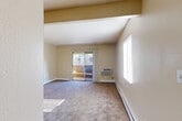 Located at 781 Hathaway Dr in Colorado Springs, CO, this two-bedroom, one-bathroom residence offers a well-organized single-level layout. The living room is a bright, open space highlighted by plush carpeting, baseboard heating, a wall-mounted A/C unit, and a sliding glass door that opens directly onto a private balcony, filling the room with natural light. Adjacent to the living room, the dining area transitions seamlessly into the kitchen, which features wood cabinetry, a white range, and hardwood-style flooring that adds warmth and contrast to the neutral palette throughout. Both bedrooms are carpeted and generously sized, each featuring vertical blind-covered windows that allow for ample natural light. The primary bedroom includes a built-in vanity area with lighted mirror, providing added convenience. The second bedroom features a large bifold closet. With six closets total, storage is a notable strength of this layout. The shared bathroom includes a full tub-shower combination. A ceiling fan in the entry area and textured ceilings add to the functional character of the space. The private balcony provides an outdoor retreat, completing this practical and comfortable Colorado Springs residence.