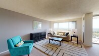 This single-floor residence offers a thoughtfully arranged layout that connects the main living spaces in an open, cohesive flow. The living room serves as the centerpiece of the unit, featuring a wide picture window that frames expansive views of the surrounding landscape, allowing natural light to fill the carpeted space. A textured ceiling adds visual depth, while neutral wall tones provide a versatile backdrop. An adjacent dining area features a bold navy accent wall, ceiling fan, and room for a full dining set, adding a distinct and inviting character to the space.

The kitchen is equipped with warm oak cabinetry, dark laminate countertops, a stainless steel sink, and a gas range, offering a compact yet functional cooking environment with tile flooring.

Two bedrooms provide comfortable accommodations, each with carpeted floors, windows offering outdoor views, and ample closet space. The primary bedroom features double closets and a warm, golden accent wall, while the second bedroom maintains a lighter, neutral palette.

Two bathrooms serve the unit — one with yellow-accented tile and a tub/shower combination, and another featuring a wide vanity countertop, wood-framed mirror, and mosaic tile flooring. Together, these spaces form a practical and characterful home.