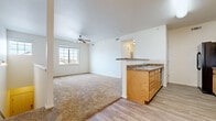 This single-floor residence offers a well-organized layout designed for comfortable everyday living. The open-concept living and dining area is finished with plush carpeting and features a ceiling fan, providing both comfort and airflow. Natural light filters in through a large window, brightening the space considerably.

The kitchen is thoughtfully designed with light oak cabinetry, granite-style countertops, and durable wood-look vinyl flooring. A peninsula with an integrated sink and additional cabinetry below separates the kitchen from the living area, creating a practical and social layout. The kitchen is fully equipped with black appliances, including a refrigerator, electric range, over-the-range microwave, and dishwasher.

The bedrooms are carpeted and well-proportioned, each featuring clean white walls, arched interior doors, and ample closet access. One bedroom includes a generously sized walk-in closet outfitted with wire shelving systems along multiple walls, offering abundant storage.

The bathroom is finished with wood-look vinyl flooring and includes a single-sink vanity with oak cabinetry and a granite-style countertop, a wall mirror, and a full tub-shower combination. Throughout the unit, a neutral color palette and clean finishes create a bright, cohesive aesthetic.