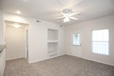 This single-floor residence offers a clean, functional layout designed for comfortable everyday living. The entryway features tile flooring that transitions into plush carpeting throughout the living area and bedrooms, creating a welcoming and cozy atmosphere. The open living space is equipped with a ceiling fan and recessed lighting, providing both comfort and illumination.

The kitchen is well-appointed with white cabinetry, dark granite-style countertops, and a full suite of white appliances including a range, refrigerator, and over-the-range microwave. A breakfast bar peninsula connects the kitchen to the living area, and tile flooring extends throughout the kitchen for easy maintenance. A dedicated laundry area with a washer and dryer is conveniently accessible directly from the kitchen.

The bedrooms are generously sized, each featuring soft carpet, ceiling fans with light fixtures, and windows that invite natural light. The bathroom includes a white vanity with dark countertops, a wall-mounted storage cabinet, and tile flooring. A spacious walk-in closet is accessible directly from the bathroom, offering ample storage. Throughout the residence, neutral wall tones and clean finishes create a bright, move-in-ready environment.