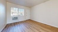 Located at 977 N Highland St in Orange, California, this efficient single-story residence offers a thoughtfully arranged layout comprising a living room, bedroom, kitchen, bathroom, and closet. Throughout the space, light wood-style flooring creates a clean, cohesive aesthetic that complements the neutral, cream-toned walls.

The living room is bright and open, featuring vertical blinds on a large window that allow natural light to filter in, along with a wall-mounted heating and cooling unit for year-round comfort. The galley-style kitchen is efficiently designed with white cabinetry, granite-look countertops, a gas range, and a full-size refrigerator — maximizing every inch of available space.

The bedroom is a comfortable, well-lit retreat with a ceiling fan, a generously sized window with views of outdoor greenery, and a dedicated walk-in closet outfitted with built-in shelving and hanging rods for ample storage.

The bathroom features a tub-shower combination with sliding glass doors, a classic pedestal sink, tile flooring, and a mirrored medicine cabinet. The overall ambiance of the space is light, clean, and functional — ideal for those seeking a manageable, low-maintenance residence in Orange, CA.