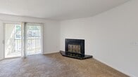 Located at 4524 Newby Dr in Durham, NC, this single-floor, 2-bedroom, 2-bathroom home offers a practical and comfortable layout. The living room serves as the heart of the home, highlighted by a striking black-tiled fireplace with brass-framed glass doors and large sliding glass doors that invite natural light and outdoor views. Adjacent to the living area, the kitchen is well-equipped with stainless steel appliances—including a refrigerator, electric range, and dishwasher—paired with wood-toned cabinetry, white upper cabinets, and a double sink. A ceiling fan and window in the dining area provide additional light and airflow. Both bedrooms feature soft wall-to-wall carpeting, generous closet space with paneled doors, and neutral white walls. The primary bedroom includes direct access to one of the two full bathrooms. Each bathroom is outfitted with a tub-shower combination featuring white tile surround and wood-look vinyl flooring, maintaining a clean, cohesive aesthetic throughout. Textured ceilings are present across the home, adding a classic residential character. The thoughtful layout, dual closets, and functional finishes make this Durham home a well-rounded living space.