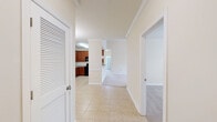 This well-appointed three-bedroom, two-bathroom residence in Duncan, SC offers a thoughtfully designed single-floor layout with generous living space throughout. The open-concept living room features vaulted ceilings with a ceiling fan, creating an airy, expansive atmosphere that flows seamlessly into the kitchen. The kitchen is equipped with rich warm-toned cabinetry, granite countertops, black appliances including a refrigerator, range, microwave, and dishwasher, and tile flooring, all complemented by pendant lighting and a breakfast bar pass-through. The spacious primary bedroom includes a walk-in closet and an en-suite bathroom featuring a dual-sink granite vanity with warm wood cabinetry and dual mirrors. The second bathroom offers a full tub-shower combination with brushed nickel fixtures. Additional bedrooms are carpeted and filled with natural light from large windows overlooking the surrounding neighborhood. Three closets provide ample storage throughout the unit. A dedicated laundry room with washer and dryer hookups, wire shelving, and tile flooring adds everyday convenience. Soft neutral tones, plush carpeting in living and bedroom areas, and consistent crown molding details contribute to the cohesive and comfortable ambiance of this residence.