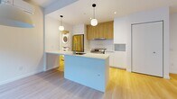 Located at 2812 Rue Ontario E in Montréal's vibrant Hochelaga-Maisonneuve neighbourhood, this well-designed 2-bedroom, 1-bathroom unit offers a thoughtful and functional layout across a single floor. Light hardwood flooring runs throughout, lending warmth and visual continuity to every room.

The open-concept living and dining area is bright and airy, with large windows and a sliding glass door that invites natural light deep into the space. A wall-mounted air conditioning unit and baseboard heating ensure year-round comfort. The contemporary kitchen features a central island with an integrated sink, crisp white lower cabinetry paired with natural wood upper cabinets, stainless steel appliances including a range and refrigerator, and a subway tile backsplash. Pendant lighting adds a modern finishing touch. An in-unit stacked washer and dryer is conveniently tucked nearby.

Both bedrooms are finished with the same light hardwood flooring and clean white walls. The primary bedroom benefits from a walk-in closet, while the second bedroom features its own dedicated closet. The full bathroom is elegantly appointed with large-format beige tiles, a soaking tub, a glass-enclosed shower, and a wood-accented vanity with an undermount sink.
