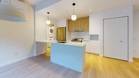 Located at 2812 Rue Ontario E in Montréal's vibrant Hochelaga-Maisonneuve neighbourhood, this well-designed 2-bedroom, 1-bathroom unit offers a thoughtful and functional layout across a single floor. Light hardwood flooring runs throughout, lending warmth and visual continuity to every room.

The open-concept living and dining area is bright and airy, with large windows and a sliding glass door that invites natural light deep into the space. A wall-mounted air conditioning unit and baseboard heating ensure year-round comfort. The contemporary kitchen features a central island with an integrated sink, crisp white lower cabinetry paired with natural wood upper cabinets, stainless steel appliances including a range and refrigerator, and a subway tile backsplash. Pendant lighting adds a modern finishing touch. An in-unit stacked washer and dryer is conveniently tucked nearby.

Both bedrooms are finished with the same light hardwood flooring and clean white walls. The primary bedroom benefits from a walk-in closet, while the second bedroom features its own dedicated closet. The full bathroom is elegantly appointed with large-format beige tiles, a soaking tub, a glass-enclosed shower, and a wood-accented vanity with an undermount sink.