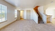 Located at 201 Burrows Road in Red Lion, PA, this three-floor home offers generous living space across its well-organized layout. The ground level houses a garage with concrete flooring and an automatic door, plus an entrance that opens to a bright hallway featuring light hardwood-style flooring and carpeted staircases connecting all three levels. The expansive main floor serves as the heart of the home, accommodating the kitchen, bedrooms, bathrooms, and key living areas. The kitchen is outfitted with warm honey-toned cabinetry, dark countertops, stainless steel appliances including a gas range, built-in microwave, and dishwasher, all set over durable light wood-look flooring. The bedrooms are carpeted and filled with natural light from multiple windows; the primary bedroom features vaulted ceilings and a ceiling fan, creating an airy retreat. A dedicated walk-in closet with wire shelving provides ample storage. The bathrooms are clean and functional, with a full tub-shower combo. The upper level adds additional flexible space. Outdoors, a wooden deck with white railings offers sweeping views of lush green lawn and a wooded hillside, providing a serene natural backdrop ideal for relaxing or entertaining.