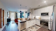 Located at 2801 Windy Ridge Pkwy SE in Smyrna, Georgia, this well-appointed 2-bedroom, 1-bathroom residence offers a thoughtfully designed single-level floor plan. The open-concept kitchen and living area serves as the heart of the home, featuring white shaker cabinetry, herringbone tile backsplash, dark quartz countertops, stainless steel appliances including a refrigerator, range, microwave, and dishwasher, and stylish pendant lighting over the kitchen island. The living area flows naturally from the kitchen and is bathed in natural light from large windows, with a ceiling fan overhead and direct access to a private balcony overlooking lush greenery. Both bedrooms are comfortably sized, each offering large windows with outdoor views, ceiling fans, and carpeted flooring for added comfort. The primary bedroom includes a dedicated closet with wire shelving. The full bathroom features large-format tile surround, a soaking tub and shower combination, and wood-look vinyl plank flooring that extends throughout the main living areas. Additional conveniences include a dedicated laundry area, a utility room, and ample closet storage throughout the home.