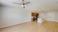Located at 11110 Lantern Rd in Fishers, Indiana, this well-appointed 2-bedroom, 2-bathroom single-floor home offers a thoughtfully designed layout with modern finishes throughout. The open-concept living and kitchen area forms the heart of the home, showcasing light hardwood-style flooring, crisp white walls, and a ceiling fan that enhances the airy feel of the space. Large windows invite natural light and provide views of the surrounding greenery.

The kitchen is a standout feature, centered around a generous white quartz island with an undermount sink and stylish globe pendant lighting. Rich dark wood cabinetry, a subway tile backsplash, and a full suite of stainless steel appliances—including a refrigerator, electric range, and built-in microwave—complete this functional and attractive space.

Both bedrooms are carpeted for comfort and include ceiling fans and windows with natural light. The spacious primary bedroom connects to a walk-in closet equipped with wire shelving for ample storage. The bathrooms feature quartz countertops, dark wood vanities, and a tub-shower combination with clean white surrounds. A dedicated laundry room houses a full-size washer and dryer with overhead wire shelving, adding everyday convenience to this well-rounded home.