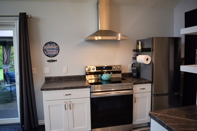 Full size stove/oven with a larger compact refrigerator. - 5041 E 32 Rd