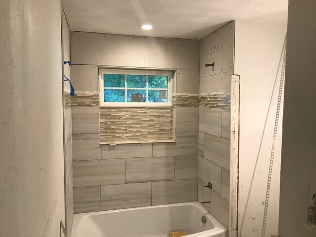 In progress of the bathroom remodel. I am loving the new tile work! All new everything; toilet, tub, tile work, window, sink, cabinet. - 6520 Finch
