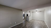This 860 square foot apartment in Grand Prairie, TX offers a well-designed living space with two bedrooms and two bathrooms. The interior showcases a modern aesthetic with neutral color palette and contemporary finishes. The open-concept layout maximizes the use of space, creating a seamless flow between the living area and kitchen.

The flooring throughout is a durable, wood-look material that adds warmth and character to each room. The primary bedroom, measuring 100 square feet, provides a cozy retreat with ample natural light from the window. Both bedrooms feature ceiling fans for added comfort.

The kitchen is equipped with updated appliances, including a black refrigerator, and boasts granite countertops and a tiled backsplash. The bathrooms are tastefully appointed with tiled surrounds in the shower/tub area, featuring an accent strip for visual interest.

The living area is brightened by large windows and a sliding glass door, allowing natural light to flood the space. Built-in closets in both bedrooms offer practical storage solutions. The overall design emphasizes functionality and modern living, making efficient use of the compact 860 square foot floor plan.