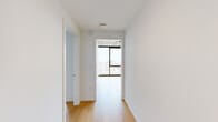 This efficiently designed 4-bedroom, 2-bathroom unit occupies a single floor in a high-rise building, offering a contemporary aesthetic defined by clean white walls, light hardwood flooring, and exposed concrete ceilings throughout. The open-plan kitchen and living area serves as the central hub of the unit. The kitchen features stainless steel appliances—including a range, dishwasher, and refrigerator—paired with light wood cabinetry and neutral countertops. The living area connects seamlessly to the kitchen and opens toward floor-to-ceiling windows that frame expansive urban views.

The four bedrooms maintain the unit's consistent modern palette of white walls and hardwood floors. The primary bedroom benefits from large windows with sweeping city views, while the additional bedrooms are finished with the same clean aesthetic. Two full bathrooms serve the unit; one features a soaking tub with white subway-style tile surround and matte black fixtures. A dedicated laundry room houses a stacked Electrolux washer and dryer unit. Two hallways connect the rooms efficiently. The overall ambiance is bright, minimal, and contemporary, elevated by the high-rise vantage point and abundant natural light.