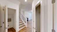Located at 3900 Salem Road in Covington, Georgia, this two-story home offers five bedrooms and three bathrooms across a thoughtfully designed floor plan. The main level features a combined kitchen and living area, where the kitchen stands out with crisp white shaker cabinetry, granite countertops, a center island with a built-in sink, stainless steel appliances, and recessed lighting — all complemented by light hardwood-style flooring that flows throughout the home. The living area benefits from abundant natural light through large windows and a glass door that opens to the outdoors. A staircase with wood treads and black balusters connects the two floors, anchored by a classic newel post. The upper level houses the majority of the bedrooms, including a generously sized primary bedroom with an en suite bathroom featuring granite countertops, a soaking tub, and ample natural light. Additional bedrooms are bright and well-proportioned, each with windows overlooking the surrounding greenery. The home also includes a walk-in closet with wire shelving, a dedicated hallway, and clean, neutral finishes throughout that lend a fresh, move-in-ready feel to every room.