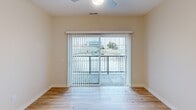 Located at 900 3rd St SE in Cedar Rapids, Iowa, this thoughtfully designed one-bedroom, one-bathroom unit offers a clean, modern aesthetic throughout its efficiently utilized single-floor layout. Warm-toned walls and light wood-style flooring flow seamlessly through the main living areas, creating a bright and cohesive atmosphere.

The open-concept kitchen and living area serves as the heart of the unit. The kitchen is outfitted with crisp white shaker cabinetry, gleaming stainless steel appliances — including a refrigerator, range, and microwave — and a white quartz peninsula with a built-in sink and pendant lighting above, providing both additional prep space and a casual dining option.

The living area extends to a sliding glass door that opens onto a private balcony, offering views of the surrounding Cedar Rapids cityscape and filling the space with natural light. Vertical blinds provide flexible light control.

The bedroom features soft carpeting, a ceiling fan with integrated lighting, and a window with urban views. A hallway connects the main areas to the full bathroom, which includes a white vanity, mirror, and a tub-shower combination with clean, light wood flooring.

A dedicated laundry area houses a stacked Samsung washer and dryer unit alongside a spacious walk-in closet with wire shelving, adding practical convenience to everyday living.
