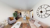 Located at 234 E Main St in Plainfield, Indiana, this single-floor, one-bedroom, one-bathroom unit offers a thoughtfully designed open-concept layout with modern finishes throughout. The living and kitchen areas flow seamlessly together, anchored by light wood-look flooring and crisp white walls that create a bright, welcoming atmosphere. The kitchen is well-appointed with rich dark-stained shaker cabinets, granite countertops, a subway tile backsplash, and a full suite of stainless steel appliances including a refrigerator, range, and microwave. A central island with granite counters and bar seating adds both functionality and style, complemented by a modern pendant light above. The open living area is bathed in natural light from large windows and a glass-paned door that leads to an exterior entrance, providing an airy, connected feel. The bedroom is a comfortable retreat featuring plush carpet, multiple windows with natural light, and access to a spacious walk-in closet outfitted with wire shelving and hanging storage. The bathroom includes a dark wood vanity with granite countertops, a tub-shower combination with white subway tile surround, and wood-look flooring. A utility room and hallway round out the functional layout of this well-designed unit.