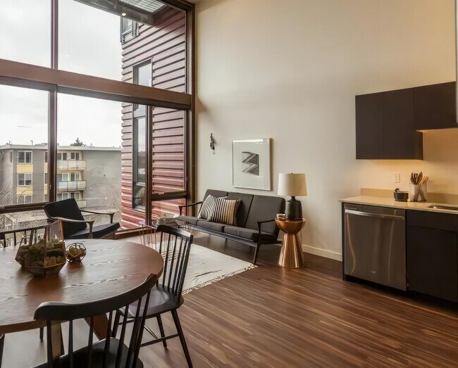 La luz natural llega a dos pisos a la vez a través de estos altos ventanales frontales. - Ballard Public Lofts