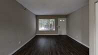 Located at 15025 Greenhaven Dr in Burnsville, MN, this one-bedroom, one-bathroom unit is thoughtfully laid out across a single floor. The living room serves as a welcoming entry point, featuring dark hardwood-style flooring, neutral taupe walls, and a textured ceiling. A large window and a glass-panel front door allow natural light to fill the space, offering pleasant outdoor views of surrounding greenery. An additional area adjacent to the living room provides flexible use as a dining or secondary lounge space.

The kitchen is well-appointed with white shaker-style cabinetry, granite-look countertops, a subway tile backsplash, and stainless steel appliances including a refrigerator and range. Wood-look flooring continues throughout, and ample cabinet storage runs along both sides of the galley-style layout.

The bedroom is a comfortable, carpeted retreat featuring a window with outdoor views, neutral wall tones, and a wide double-door closet offering generous storage. The bathroom includes a full-size soaking tub with clean white tile surround and chrome fixtures, maintaining a simple and functional aesthetic throughout. Overall, the unit presents a practical and cohesive design with consistent neutral finishes across all rooms.