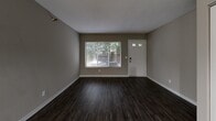 Located at 15025 Greenhaven Dr in Burnsville, MN, this one-bedroom, one-bathroom unit is thoughtfully laid out across a single floor. The living room serves as a welcoming entry point, featuring dark hardwood-style flooring, neutral taupe walls, and a textured ceiling. A large window and a glass-panel front door allow natural light to fill the space, offering pleasant outdoor views of surrounding greenery. An additional area adjacent to the living room provides flexible use as a dining or secondary lounge space.

The kitchen is well-appointed with white shaker-style cabinetry, granite-look countertops, a subway tile backsplash, and stainless steel appliances including a refrigerator and range. Wood-look flooring continues throughout, and ample cabinet storage runs along both sides of the galley-style layout.

The bedroom is a comfortable, carpeted retreat featuring a window with outdoor views, neutral wall tones, and a wide double-door closet offering generous storage. The bathroom includes a full-size soaking tub with clean white tile surround and chrome fixtures, maintaining a simple and functional aesthetic throughout. Overall, the unit presents a practical and cohesive design with consistent neutral finishes across all rooms.