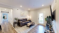 Located on Town Square Blvd in Pendergrass, GA, this well-appointed 2-bedroom, 2-bathroom residence offers a thoughtfully designed single-floor layout with modern finishes throughout. The open-concept living area features hardwood-style flooring, crown molding, recessed lighting, and a glass-panel exterior door that invites natural light into the space. The kitchen is a standout feature, boasting white shaker cabinetry, a striking blue shiplap island with seating for multiple guests, white quartz countertops, a navy tile backsplash, and a full suite of stainless steel appliances. The spacious primary bedroom is bathed in natural light from multiple windows with neutral-toned drapes and offers ample room to relax. The second bedroom provides a cozy retreat with closet storage and warm, neutral décor. The bathrooms are finished with white shaker cabinetry, dual vanities, black hardware accents, and generous built-in storage. Consistent hardwood-style flooring flows throughout the entire home, tying each space together cohesively. The overall ambiance is clean, modern, and inviting — a well-designed residence ideal for comfortable everyday living in a growing Georgia community.