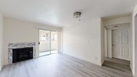 Located at 1250 N June St in the heart of Hollywood, Los Angeles, this well-appointed 1-bedroom, 1-bathroom unit offers a thoughtfully designed layout across a single floor. The living room serves as the centerpiece of the space, featuring light wood-style flooring, crisp white walls, and a stone-tiled fireplace that adds warmth and character. A sliding glass door leads to a private balcony, filling the room with natural light and providing an outdoor retreat. The galley-style kitchen is outfitted with white shaker cabinetry, light quartz countertops, a stainless steel gas range, microwave, and dishwasher, all set atop neutral tile flooring for a clean, functional look. The bedroom is a quiet, well-lit space with the same light wood flooring and a large window offering additional natural light. The bathroom features a full tub-shower combination, a white vanity with undermount sink, quartz countertop, and a large mirror with elegant pendant lighting overhead. Two hallways connect the rooms efficiently, contributing to a smart and practical flow throughout the unit. The overall ambiance is modern, bright, and move-in ready.