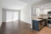 Located at 3900 Fir Tree in Riverside, California, this single-floor unit offers a clean, contemporary design with a cohesive aesthetic carried throughout each room. Wood-look plank flooring spans the living areas and bedrooms, providing warmth and easy maintenance, while neutral gray walls create a versatile backdrop suited to a variety of décor styles.

The open living area is bright and airy, featuring a large sliding glass door covered by vertical blinds that allows generous natural light to fill the space. Ceiling fans with integrated lighting are installed throughout the unit, ensuring year-round comfort and airflow.

The kitchen is well-equipped with stainless steel appliances, including an electric range with a matching over-the-range microwave, set against crisp white upper cabinetry and dark lower cabinetry. Light-toned countertops provide ample workspace, and recessed lighting adds a polished finishing touch.

Multiple bedrooms offer a comfortable and quiet retreat, each featuring the same wood-look flooring, ceiling fans, and windows with blinds that let in natural light. The bathroom includes a wide vanity with light countertops, an integrated sink, a large wall mirror, and textured walls that add subtle character. The textured ceilings found throughout the unit tie the overall design together with a consistent, residential feel.