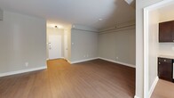 Located at 1500 Arlington Blvd in Arlington, Virginia, this one-bedroom, one-bathroom residence offers a practical and well-designed single-floor layout. Warm hardwood-style flooring runs throughout the unit, complementing the neutral, taupe-toned walls that create a clean and cohesive aesthetic.

The combined kitchen and living area serves as the heart of the home. The kitchen is efficiently designed, featuring dark wood cabinetry, granite countertops, stainless steel appliances including a gas range and refrigerator, and a subway tile backsplash. A window allows natural light to filter in, adding brightness to the space.

The open living area provides generous room for flexible furniture arrangements and benefits from additional natural light through windows dressed with horizontal blinds. A ceiling fan with an integrated light fixture adds both function and character.

The bedroom is a well-proportioned retreat, also featuring a ceiling fan, hardwood-style flooring, and a window with outdoor views. A dedicated closet provides convenient storage. The bathroom is clean and functional, featuring a full tub-shower combination with white tile surround, a pedestal-style sink, and coordinating flooring.

The entry foyer offers a welcoming transition into the home. Overall, this residence delivers a comfortable and practical living experience in a desirable Arlington location.