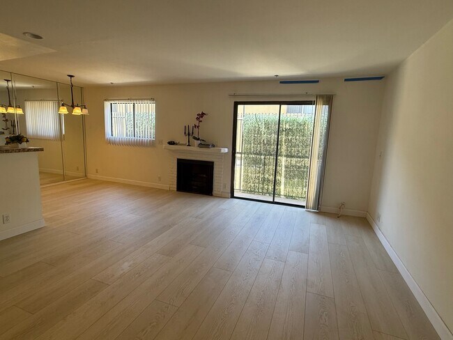 Living room with new vinyl wood floors, Faux fireplace, sliding door to Emergency Walkway - 4322 Matilija Ave