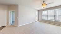 Located at 1711 Lake Superior Rd in Valparaiso, Indiana, this thoughtfully designed one-bedroom, one-bathroom unit offers a comfortable and functional layout across a single floor. The open-concept living area features neutral-toned carpeting, soft gray walls, and a ceiling fan with light fixture, creating a warm and inviting atmosphere. A glass-panel door leads to a private balcony that overlooks a well-maintained green lawn and the attractively designed neighboring buildings, offering pleasant outdoor views under open skies. The kitchen is a standout feature, showcasing rich dark-stained cabinetry, granite countertops, stainless steel appliances including a gas range, microwave, and refrigerator, and a peninsula with pendant lighting that connects seamlessly to the living space. Hardwood-style flooring runs through the kitchen, which also conveniently houses a stacked in-unit washer and dryer. The bedroom is a comfortable, carpeted retreat with natural light from a window overlooking the community. The bathroom is finished with a granite-topped vanity, an undermount sink, and brushed nickel fixtures. A dedicated closet provides practical storage, completing this well-rounded and move-in-ready space.