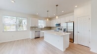Located at 2350 N Narcoossee Rd in Saint Cloud, FL, this two-story home offers 3 bedrooms, 4 bathrooms, and a well-organized layout spread across two floors. The main level hosts a bright, open-concept living, dining, and kitchen area finished with light wood-look flooring and a clean, neutral palette. The kitchen is a standout feature, showcasing white shaker-style cabinetry, a large center island with quartz countertops, a subway tile backsplash, stainless steel appliances, and elegant pendant lighting. A dedicated pantry and recessed lighting throughout add to the kitchen's functionality and appeal. The main floor also includes an attached garage with concrete flooring and painted concrete block walls, as well as a covered brick-paver patio offering views of the surrounding green lawn. Upstairs, the second floor houses all three bedrooms, including a generously sized primary suite complete with an en-suite bathroom featuring a walk-in glass shower, white vanity, and quartz countertop. Additional bedrooms are well-proportioned with built-in closets and natural light from windows. The home also includes five closets, a dedicated laundry area, a utility room, and two staircases, ensuring practical storage and circulation throughout.