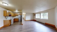 Located at 2061 McKnight Road North in North Saint Paul, Minnesota, this 2-bedroom, 1-bathroom unit offers a functional and comfortable single-floor layout. The open-concept kitchen and living area serves as the heart of the space, with the kitchen featuring warm oak cabinetry, light countertops, a white electric range, and a stainless steel refrigerator. The living area extends generously from the kitchen, bathed in natural light from a large picture window that overlooks the surrounding greenery. Consistent hardwood-style flooring and warm wood trim run throughout the unit, lending a cohesive and clean aesthetic. Baseboard heating is present throughout, providing efficient warmth during Minnesota winters. The primary bedroom is a comfortable size, offering a built-in closet with ample storage. The second bedroom also features a window with outdoor views and baseboard heating. Both bedrooms are well-proportioned and bright. The full bathroom includes a single-sink vanity with updated cabinetry, a full tub-shower combination, and light flooring. The unit's straightforward layout and practical finishes make it a well-organized and move-in ready living space.