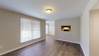 Located at 4803 New Hope Rd in Raleigh, NC, this single-floor home offers a well-designed layout with a cohesive blend of comfort and functionality. The open living and dining area is anchored by rich, dark hardwood-style flooring that flows throughout the main living spaces, complemented by neutral-toned walls that create a bright and welcoming atmosphere. Large windows dressed with horizontal blinds allow abundant natural light to fill the living room, while a pass-through window connects it seamlessly to the kitchen. A pendant chandelier marks the dining area, adding a touch of elegance to the space. The galley-style kitchen is well-appointed with dark espresso cabinetry, granite-patterned countertops, and black appliances including a refrigerator, range, and dishwasher. The bedrooms offer plush carpeting underfoot, ceiling fans with light fixtures, and windows that invite natural light. One bedroom features a connected bathroom, providing added privacy and convenience. The bathroom showcases a dark wood vanity with a granite-style countertop, a framed mirror, and wood-look flooring that ties back to the home's overall aesthetic. Throughout the residence, clean white trim and neutral finishes contribute to a polished, move-in-ready presentation.