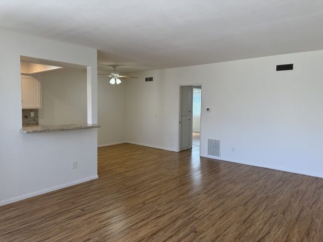 Apartamento n.º 5: Vista desde la sala de estar hacia la ventana que comunica con la cocina y el pasillo que lleva a los dormitorios. - 321 E Dryden St