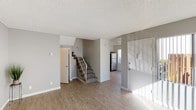Located at 5544 Balboa Arms #G18 in San Diego, this two-story unit offers a practical and well-organized layout across two levels. The main floor features an open living area with light wood-style vinyl flooring, neutral gray walls, and a textured ceiling. Large sliding doors allow natural light to fill the space, creating a bright and airy atmosphere. A carpeted staircase with white railings connects the two floors seamlessly.

The kitchen is efficiently designed with white cabinetry, light countertops, and a full suite of stainless steel appliances including a refrigerator, electric range, and dishwasher. A half bathroom on the main level provides added convenience for guests, featuring a single-sink vanity with a stone-look countertop and a mirrored medicine cabinet.

Upstairs, the bedrooms are finished with plush carpet and feature sliding closet doors, offering comfortable and functional spaces. The upper-level full bathroom includes a single-sink vanity with a stone-look countertop, a mirrored medicine cabinet, and a shower-tub combination. Throughout the unit, a consistent neutral color palette and clean finishes contribute to a cohesive and move-in-ready feel.
