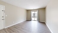 Located at Saint Anthony Gardens in Louisville, Kentucky, this 2-bedroom, 2-bathroom single-floor residence offers a clean, modern aesthetic throughout. Light-toned luxury vinyl plank flooring runs continuously across the living areas, bedrooms, and kitchen, creating a cohesive and easy-to-maintain environment.

The open living room is bright and welcoming, featuring neutral beige walls, crisp white trim, and a sliding glass door that floods the space with natural light while providing access to an outdoor area. An adjacent dining area connects seamlessly to the galley-style kitchen, which is outfitted with white shaker cabinetry, granite countertops, a subway tile backsplash, a stainless steel sink, and a full suite of stainless steel appliances including a range, microwave, and refrigerator.

The spacious primary bedroom features natural light from a large window and connects to additional rooms via six-panel white doors. The second bedroom is equally well-lit with a window and includes a full-width bi-fold closet for ample storage. Both bathrooms are finished with white tile tub-shower combinations and clean, neutral surroundings. One bathroom includes a tiled tub-shower with built-in shelving, while the second features a tub-shower combo with a grab bar for added accessibility. The overall ambiance is bright, neutral, and move-in ready.