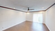 Located at 1304 McKie Dr in Austin, TX, this single-story, 3-bedroom, 2-bathroom home offers a well-organized layout connecting living, dining, and kitchen spaces in a functional open flow. Wood-look tile flooring runs throughout the main living areas and bedrooms, providing a cohesive and durable finish.

The living room is a bright, open space featuring recessed lighting, a ceiling fan, dark wood crown molding, and a large sliding glass door with vertical blinds that invites natural light into the room. The kitchen is well-appointed with rich oak cabinetry, dark granite countertops, a mosaic tile backsplash, stainless steel appliances including a range and microwave, and a built-in dishwasher. A window above the sink provides additional natural light.

The spacious primary bedroom includes a ceiling fan and its own bathroom, which features a walk-in tiled shower with decorative mosaic accents and built-in shelving. The second bathroom offers a full tub-shower combo with floor-to-ceiling tile surround, a wood vanity, and tile flooring. The additional bedrooms are bright and well-sized, each with ceiling fans. A hallway with dark wood beam accents connects the rooms, and a dedicated closet provides practical storage. The home's clean, neutral palette makes it a versatile and move-in ready space.