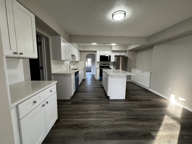 Kitchen looking towards dining room with family room behind - 1823 E 300th St