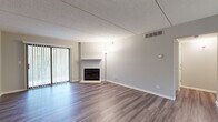 Located at 111 W Park Circle Dr in Wheaton, IL, this single-floor, one-bedroom, one-bathroom residence offers a thoughtfully designed layout across a comfortable footprint. The open-concept living room and kitchen area serves as the heart of the home, with wood-look luxury vinyl plank flooring running throughout. The living room is a standout space, anchored by a classic fireplace with a tile surround and simple mantle, while a sliding glass door with vertical blinds fills the room with natural light and provides outdoor access. Neutral gray walls complement the clean, modern aesthetic throughout.

The kitchen is efficiently designed with white cabinetry, light countertops, stainless steel appliances—including a gas range, microwave, and refrigerator—and a single basin sink beneath a gridded ceiling light panel. Light vinyl plank flooring carries through this space seamlessly.

The bedroom is generously sized, carpeted for comfort, and features a window with outdoor views and access to a dedicated walk-in closet equipped with dual wire shelving systems. The full bathroom offers a tub-shower combo, white vanity with storage, a lighted mirror, and wood-look flooring, completing the unit's clean and functional design.