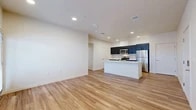 Located at 2525 S Meadows Rd in Santa Fe, NM, this thoughtfully designed 2-bedroom, 1-bathroom single-story home offers a clean, modern aesthetic throughout. Light wood-style flooring runs continuously across all rooms, lending a warm and cohesive feel to the interior. The open-concept kitchen and living area serves as the heart of the home, featuring a central island with a white quartz countertop and undermount sink, bold dark cabinetry, a classic subway tile backsplash, and a full suite of stainless steel appliances including a range, over-the-range microwave, and refrigerator. Recessed lighting illuminates the space, which also benefits from natural light and direct access to a private patio. The spacious primary bedroom includes its own walk-in closet with wire shelving, while the second bedroom offers a bright window with outdoor views. The full bathroom is equipped with a tub-shower combination. Generous closet space is distributed throughout, with five closets in total providing ample storage. A dedicated laundry area and hallway complete the layout. The overall ambiance is bright, clean, and move-in ready.
