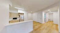 Located at 11603 NE 71st St in Vancouver, WA, this modern 2-bedroom, 2-bathroom single-floor residence offers a clean, contemporary design throughout. The open-concept kitchen and living area serves as the heart of the home, featuring light wood-tone cabinetry, white quartz countertops, stainless steel appliances including a refrigerator and range, and a peninsula that provides additional workspace and separation between the kitchen and living areas. Light hardwood flooring runs throughout the main living spaces, lending warmth and continuity to the layout. Both bedrooms are carpeted for comfort and finished with crisp white walls, offering a calm and neutral atmosphere. The primary bedroom is a well-proportioned retreat, while the second bedroom benefits from a window that brings in natural light. Two full bathrooms are tastefully designed with wood-accented vanities, hardwood-style flooring, and full soaking tubs with shower surrounds. A dedicated laundry room houses a full-size side-by-side LG washer and dryer, adding everyday convenience. A connecting hallway ties the layout together efficiently. The exterior features a lush green lawn, visible in the dollhouse view, rounding out this well-appointed and move-in-ready residence.