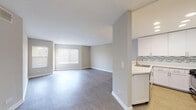 Located at 7918 Reseda Blvd in the Reseda neighborhood of Los Angeles, this single-floor unit offers a clean, modern aesthetic throughout. The open-concept living and dining area is finished with smooth gray wood-look flooring and neutral warm-toned walls, creating a bright, cohesive atmosphere. Multiple windows fitted with white horizontal blinds allow natural light to filter in, enhancing the sense of space.

The kitchen is well-appointed with white shaker-style cabinetry, sleek white countertops, and a striking mosaic tile backsplash in shades of gray and blue. Stainless steel appliances — including a gas range, over-the-range microwave, and refrigerator — complement the modern design. A breakfast bar connects the kitchen to the main living area, adding functionality.

The bedrooms are carpeted for comfort, each featuring neutral walls and windows with blinds that bring in natural light. The primary bedroom includes direct access to the bathroom, which is finished with light wood-look flooring, a white vanity with ample cabinet storage, a full-width mirror, and a clean white soaking tub with chrome fixtures. The overall design is consistent and move-in ready, with a neutral palette that provides a versatile backdrop throughout the space.