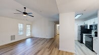 Located at 7840 Moon Rd in Columbus, Georgia, this single-story, one-bedroom, one-bathroom home offers a thoughtfully designed layout with modern finishes throughout. The combined kitchen and living area forms the heart of the home, featuring wood-look luxury vinyl plank flooring, vaulted ceilings, and a ceiling fan with light kit. Natural light fills the space through windows with blinds and a glass-paneled door leading to the exterior. The kitchen is well-appointed with white shaker cabinets, granite-style countertops, a deep single-basin sink with a matte black faucet, and black appliances including a range, microwave, and refrigerator. The bedroom is carpeted for comfort, includes a ceiling fan, and connects to a walk-in closet outfitted with wire shelving for organized storage. The full bathroom features wood-look flooring, a tub-shower combination, white cabinetry with black hardware, and clean, neutral finishes throughout. A dedicated laundry room provides washer and dryer hookups along with overhead wire shelving. The home's crisp white walls, consistent flooring, and cohesive design elements create a clean, move-in-ready atmosphere suited for comfortable everyday living.