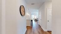 Located at 40 Hathaway Ln in Lebanon, TN, this single-story, two-bedroom, two-bathroom home offers a thoughtfully designed layout with modern finishes throughout. A welcoming hallway with warm hardwood-style flooring leads into the heart of the home, where an open-concept kitchen and living area provide a bright, connected living space. The kitchen is a standout feature, boasting white shaker cabinets, granite countertops, a large island with seating, a subway tile backsplash, stainless steel appliances, and pendant lighting. The adjacent living room is bathed in natural light from large windows and a glass door, and is anchored by a ceiling fan overhead. Both bedrooms are carpeted and well-sized, each featuring ceiling fans and ample natural light. The generously proportioned primary bedroom includes a spacious walk-in closet fitted with wire shelving. The two bathrooms are finished with granite vanity tops, white cabinetry, and tile flooring; the primary bath features a walk-in shower. A dedicated laundry room houses a full-size washer and dryer with overhead shelving for added storage. The home's clean, neutral palette and consistent finishes create a cohesive and comfortable atmosphere throughout.