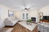 Located at 101 Montrose Ct in Dothan, Alabama, this well-appointed single-story home offers a comfortable and functional layout across two bedrooms, three bathrooms, and two closets. The living room serves as the heart of the home, featuring rich hardwood-style flooring, a ceiling fan, a classic fireplace, and French doors that invite natural light and provide outdoor access. Adjacent to the living area, the dining room is highlighted by an elegant multi-light chandelier and additional hardwood-style flooring, creating a warm and inviting space for meals and gatherings. The galley-style kitchen is equipped with warm wood cabinetry, dark green countertops, white appliances including a range, microwave, dishwasher, and refrigerator, along with a double basin sink. Both bedrooms are carpeted and feature natural light from windows. The primary bedroom includes a ceiling fan and access to a spacious walk-in closet with wire shelving. The bathrooms are fitted with warm wood vanities, white countertops, and tub-shower combinations. One bathroom features wood-look flooring and accessibility grab bars for added convenience. The home's neutral color palette and practical design make it a comfortable and versatile living space.