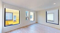 This thoughtfully designed 1-bedroom, 1-bathroom unit offers a clean, contemporary aesthetic throughout its single floor. Light-toned hardwood flooring flows seamlessly across every room, creating a sense of cohesion and warmth against the crisp white walls and ceilings.

The kitchen is a standout feature, outfitted with sleek white flat-front cabinetry extending to the ceiling for maximum storage, a vibrant cobalt blue penny-tile backsplash, stainless steel appliances including a gas range, built-in microwave, dishwasher, and refrigerator, as well as a wall-mounted mini-split HVAC unit. A large black-framed window fills the space with natural light.

The bedroom is a well-proportioned retreat with multiple large black-framed windows offering urban views, allowing generous natural light throughout the day. A wall-mounted mini-split unit ensures year-round climate comfort.

The bathroom is finished in a clean, minimalist style with a white undermount sink set in a white quartz vanity, modern chrome fixtures, and a large frameless mirror. The hallway connects all areas efficiently, maintaining an open and airy flow.

The unit's modern design, quality finishes, and abundant natural light make it a polished and functional living space.