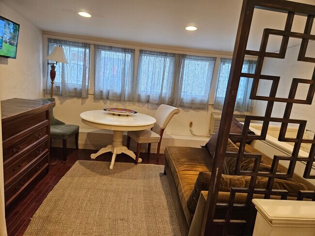 Living rm with dining section, mini bar + wall tv - 919 S Charles St