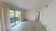 Located at 104 Clinkscales Rd in Columbia, MO, this 2-bedroom, 1-bathroom unit offers a practical and well-organized single-floor layout. The space is thoughtfully arranged to include a living room, two bedrooms, a kitchen, a full bathroom, and a hallway connecting each area seamlessly.

The kitchen is a functional highlight, featuring warm wood cabinetry, light countertops, a stainless steel refrigerator, an electric range, a built-in microwave, and a double sink. A peninsula counter extends into the adjacent living area, creating an open, connected feel between the kitchen and living spaces. A louvered closet door nearby provides convenient storage access.

Both bedrooms are carpeted and finished with neutral walls, offering a clean and versatile canvas. Each room benefits from natural light through blinded windows that overlook greenery outside. The primary bedroom includes a dedicated closet with a hanging rod and built-in shelving, providing organized storage. The bathroom is tiled in white, featuring a tub-shower combination with grab bars and a built-in storage cabinet.

Throughout the unit, the design emphasizes functionality with a neutral, light color palette that keeps the space feeling bright and open.