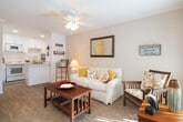 Located at 10 Nautical Mile Dr in Newport Beach, California, this single-floor residence embraces a cheerful coastal aesthetic throughout its thoughtfully designed layout. The living area serves as the heart of the home, featuring warm hardwood-style flooring, crown molding, a ceiling fan with light fixture, and a large window that invites abundant natural light. The space is well-suited for relaxing or entertaining, with a comfortable, open feel.

The kitchen is efficiently designed with crisp white shaker-style cabinetry extending to the ceiling, white quartz countertops, a stainless steel sink, an electric range, and an over-the-range microwave. The clean, bright finishes create a fresh and functional cooking space.

The bedroom offers a cozy retreat with crown molding, hardwood-style flooring, a louvered bifold closet, and a decorative wall mirror. Nautical-inspired accents complement the overall beach-house character of the home.

The full bathroom is finished with a white vanity featuring shaker cabinetry, a large mirror, a well-lit vanity bar, and a tub-shower combination. Nautical décor details carry the coastal theme seamlessly into this space.

Overall, this residence delivers a cohesive, light-filled beach-inspired atmosphere ideally suited for the Newport Beach coastal lifestyle.
