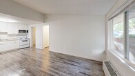 Located at 4306 Royal Glen Dr NE in Comstock Park, Michigan, this single-floor unit offers a thoughtfully organized layout that makes efficient use of its compact footprint. The combined kitchen and living room serves as the heart of the space, featuring wood-look plank flooring that extends throughout the entire unit, crisp white walls, and a sliding window that allows natural light to fill the room. A wall-mounted HVAC unit provides climate control, and the entry door opens directly into this open living area, creating a welcoming and accessible flow.

The hallway connects the main living space to the remaining rooms, maintaining a logical and easy-to-navigate layout. The bathroom is well-appointed with a white vanity offering ample counter space and cabinet storage, a full shower-tub combination, and consistent wood-look flooring that ties the space together. Brushed nickel hardware and a wall mirror add a clean, modern touch.

A dedicated closet provides convenient storage, while a separate laundry area adds a practical, in-unit amenity. The clean, neutral color palette of white walls and warm-toned flooring throughout creates a bright, cohesive ambiance. This unit is ideal for those seeking a straightforward, functional living space in a residential Comstock Park community.